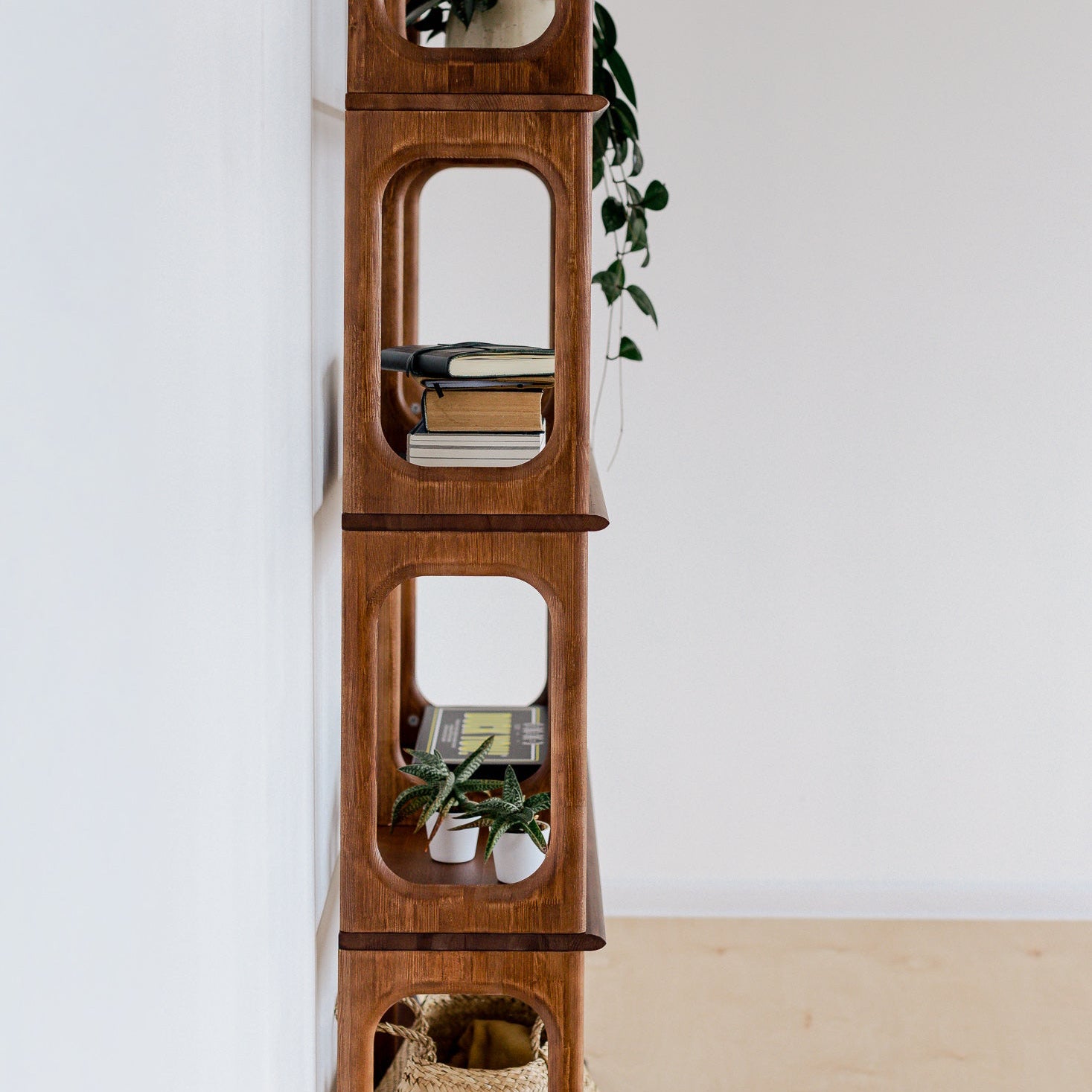 Wooden shelf with decorative items against a white wall